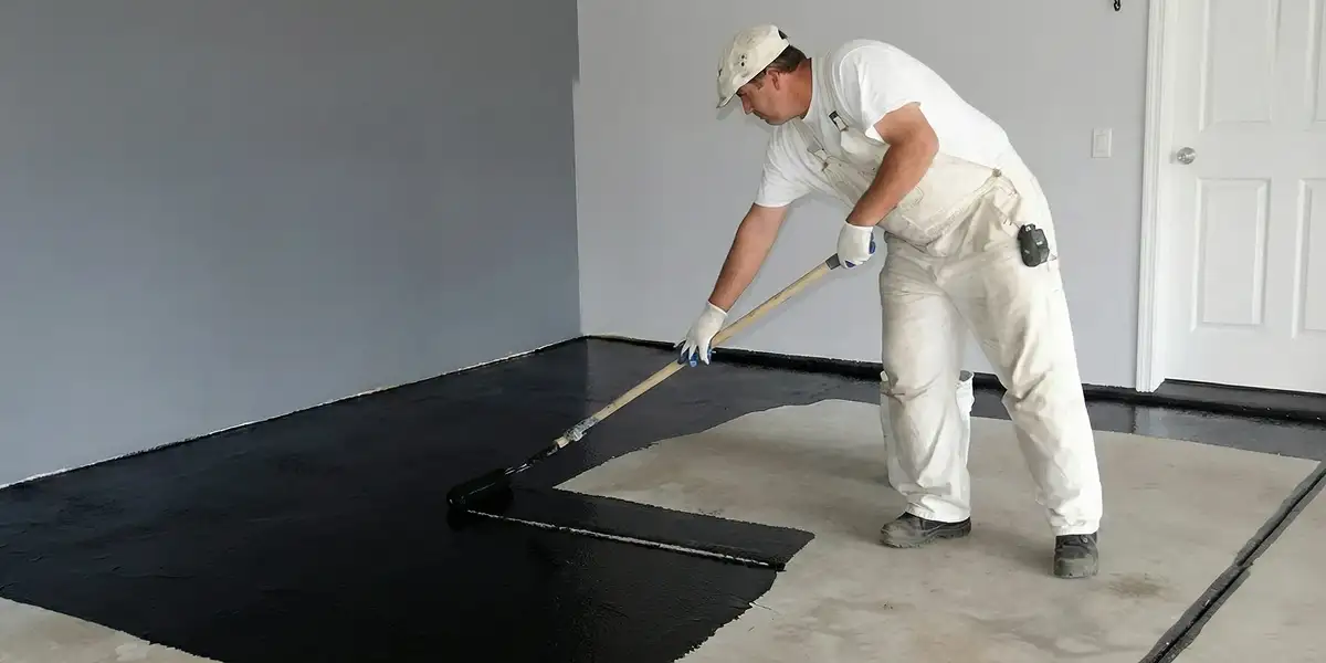 basement waterproofing professional applying waterproof coating to protect a basement floor in Salt Lake City, UT